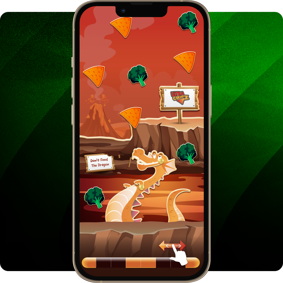 A close-up of a smartphone displaying a game level with a dragon in a rocky environment, surrounded by broccoli and triangular chips, and a sign reading “Don’t Feed The Dragon.”