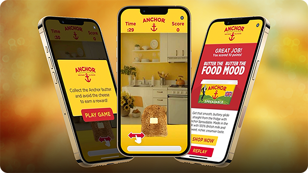 Drei Smartphones vor gelbem Hintergrund: links eine Anchor-Spielanleitung, in der Mitte ein Spiel mit Brot in einer Küche und rechts ein Belohnungsbildschirm mit einer Werbung für Anchor Spreadable.