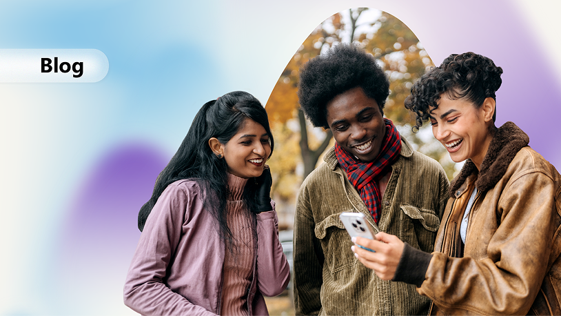 A group of three people standing outdoors in autumn, looking at a smartphone together, with a soft gradient “Blog” banner on the left side of the image.