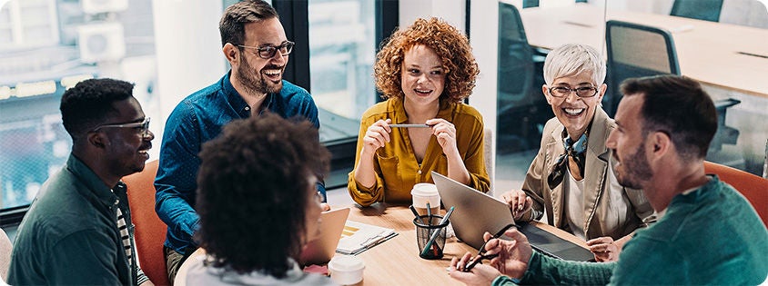 Group of business people having a meeting at a round conference table in an office.