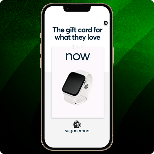Smartphone mit einer Sugarlemon-Werbung, einer weißen Smartwatch und dem Slogan „The gift card for what they love“ vor einem grün gestreiften Hintergrund.