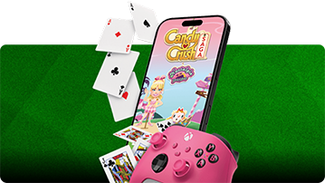 Smartphone mit Candy Crush Saga, Spielkarten und einem pinkfarbenen XBOX-Controller vor grün gestreiftem Hintergrund.
