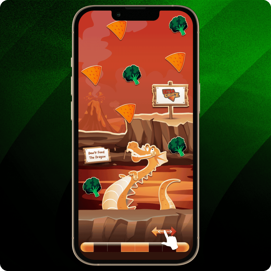 Smartphone mit einem Spiel, das einen orangefarbenen Drachen in einer felsigen Schlucht zeigt, umgeben von dreieckigen Chips und Brokkoli, mit den Schildern „Don’t Feed The Dragon“ und „Cheese Craze“.