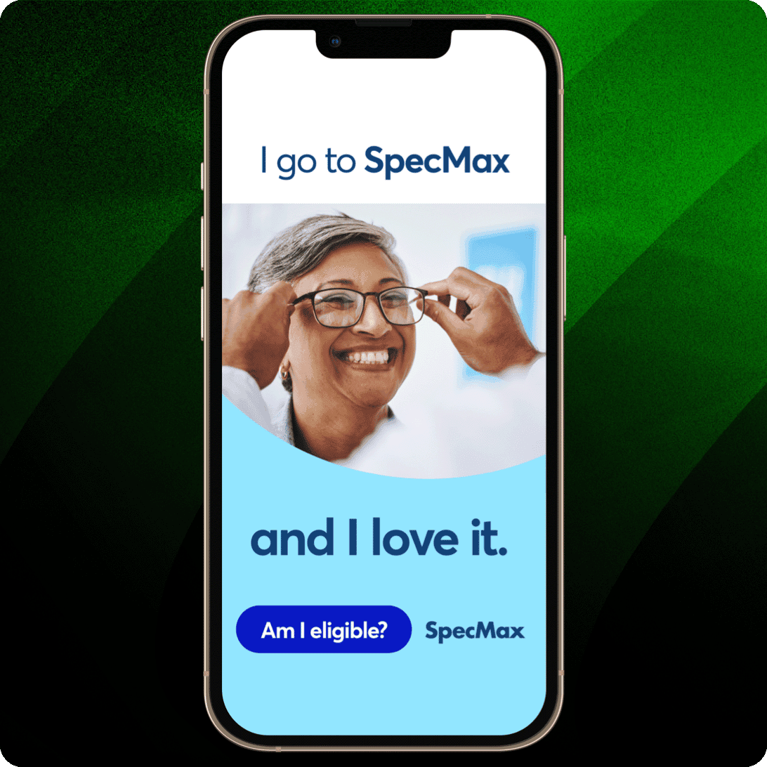 Smartphone mit einer SpecMax-Werbung, die eine Frau beim Anprobieren einer Brille zeigt, mit dem Text „I go to SpecMax and I love it“ und dem Button „Am I eligible?“.